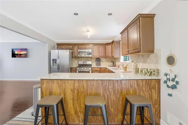 a kitchen with kitchen island granite countertop wooden cabinets a counter top space and stainless steel appliances