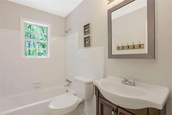 a bathroom with a sink a toilet and a mirror