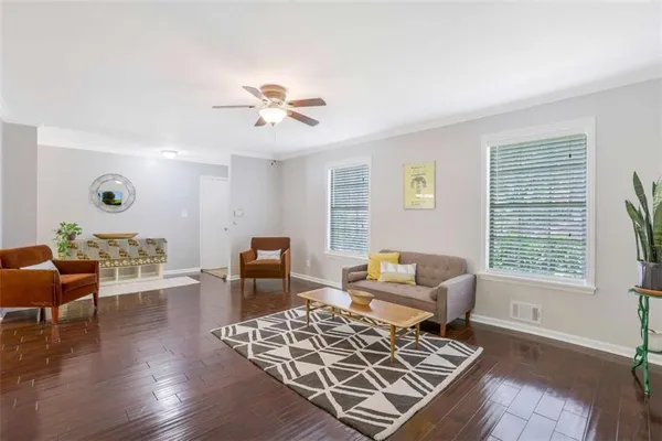 a living room with furniture and wooden floor