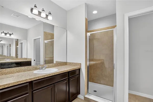 a bathroom with a granite countertop sink a mirror and a shower
