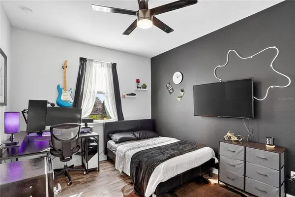 a bedroom with bed and a flat tv screen on the dresser