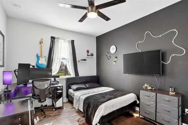 a bedroom with bed and a flat tv screen on the dresser