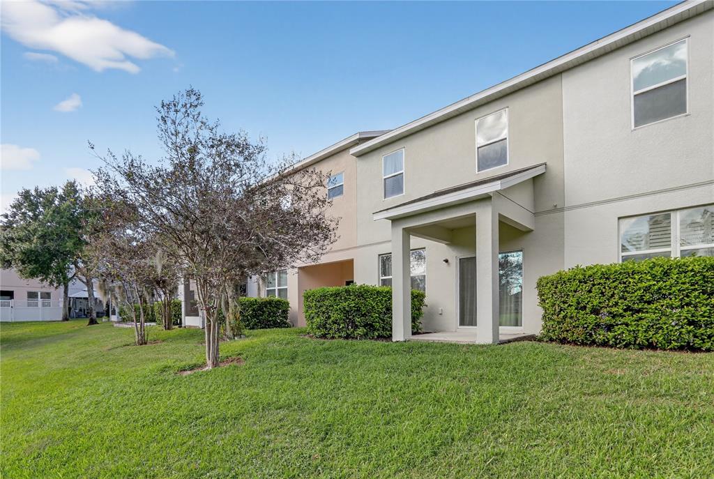 613 Fortanini Circle Ocoee, FL 34761 - Photo 22 of 24 a view of a white house next to a yard with big trees