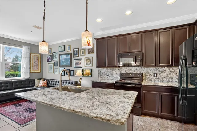 a kitchen with kitchen island granite countertop a sink stove and wooden cabinets