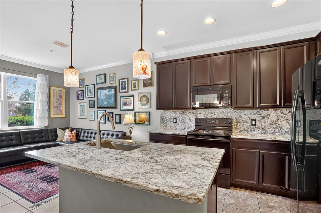 613 Fortanini Circle Ocoee, FL 34761 - Photo 3 of 24 a kitchen with kitchen island granite countertop a sink stove and wooden cabinets