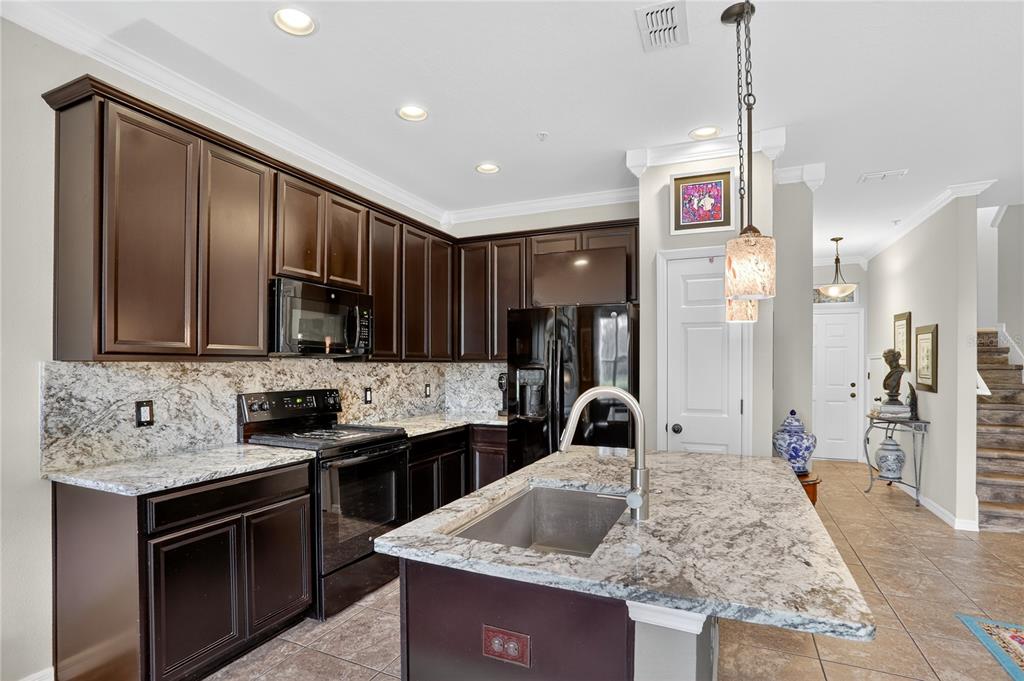613 Fortanini Circle Ocoee, FL 34761 - Photo 4 of 24 a kitchen with stainless steel appliances granite countertop a sink stove and refrigerator