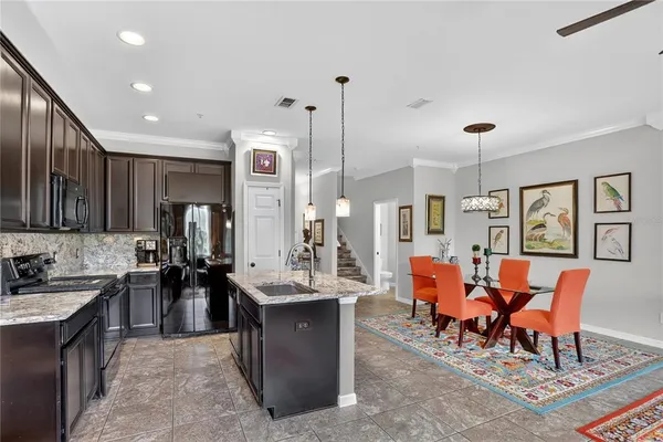 a large kitchen with lots of furniture a sink appliances and cabinets