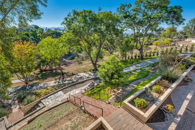 a view of a patio with couches and table and chairs with potted plants and big yard