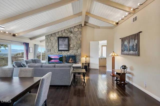 a living room with furniture a rug wooden floor and a large window