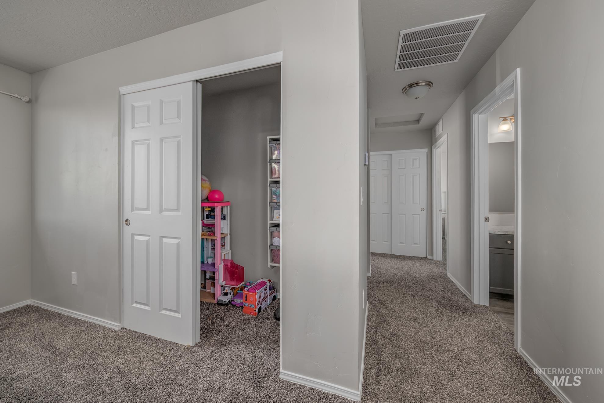 1049 Price Road Weiser, ID 83672 - Photo 23 of 47 Hallway featuring gray carpet flooring, white trim, and light gray wall paint