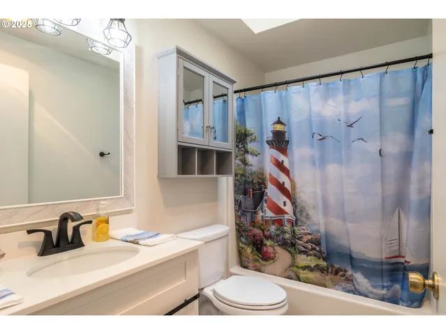 a bathroom with a sink a toilet and shower curtain