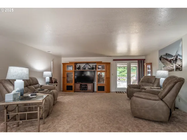 a living room with furniture a large window and a fireplace