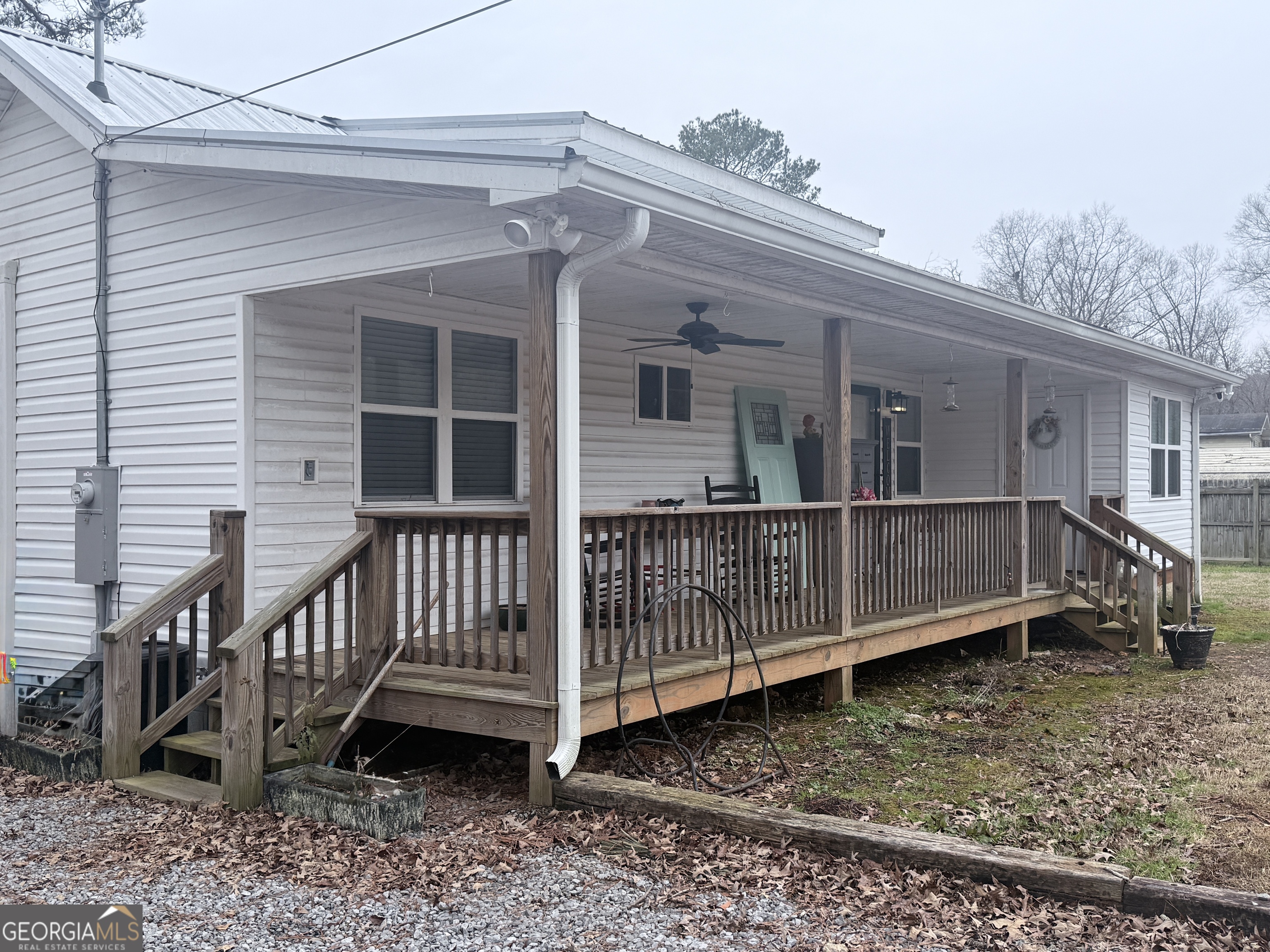 a view of a house with a small yard and wooden fence