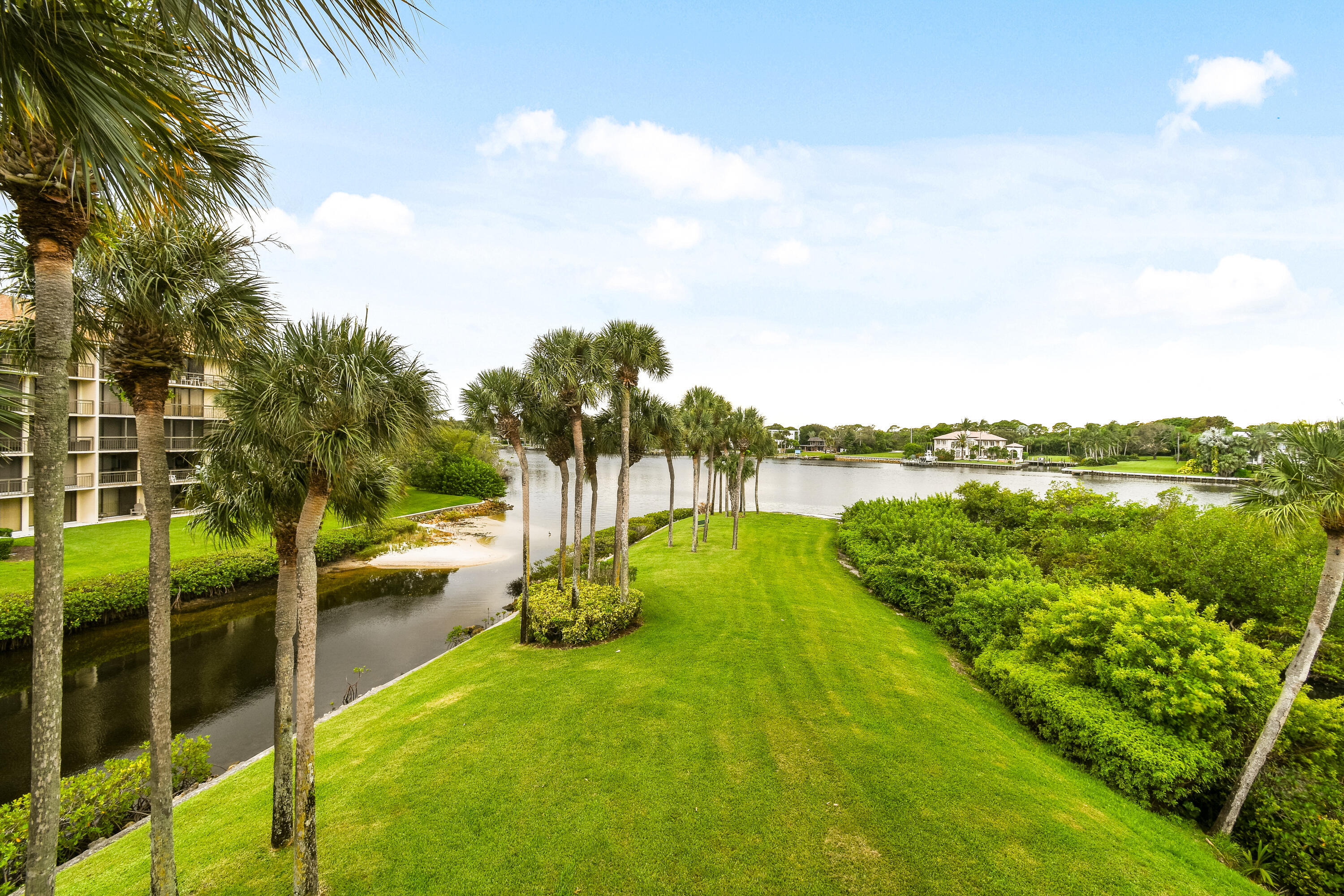 1701 Marina Isle Way, Unit 301 Jupiter, FL 33477 - Photo 2 of 60 a view of a lake with a garden