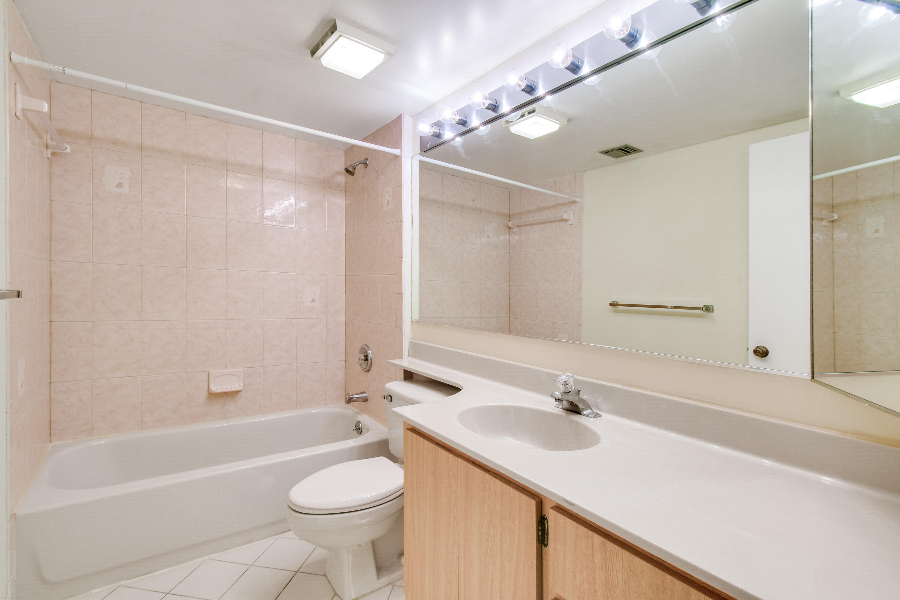 1701 Marina Isle Way, Unit 301 Jupiter, FL 33477 - Photo 34 of 60 a bathroom with a sink a toilet a mirror a vanity and bathtub