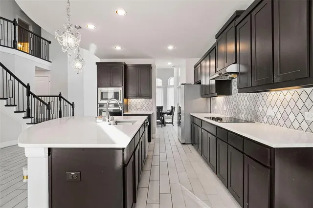 a large kitchen with kitchen island a sink appliances and cabinets