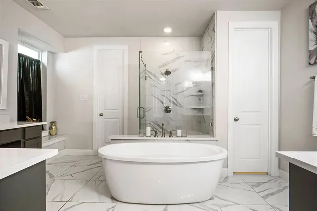 a bathroom with a bathtub and a glass door shower