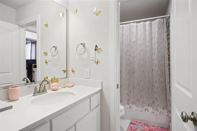 a bathroom with a sink vanity granite tub shower and a mirror