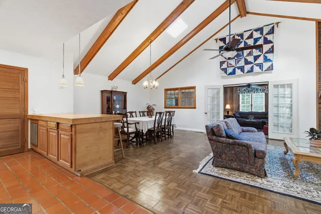 a living room with furniture a dining table and a large window