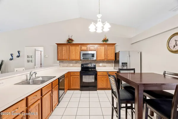 a kitchen with a sink a stove and chairs