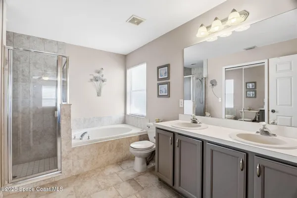 a bathroom with a double vanity sink toilet mirror and bathtub