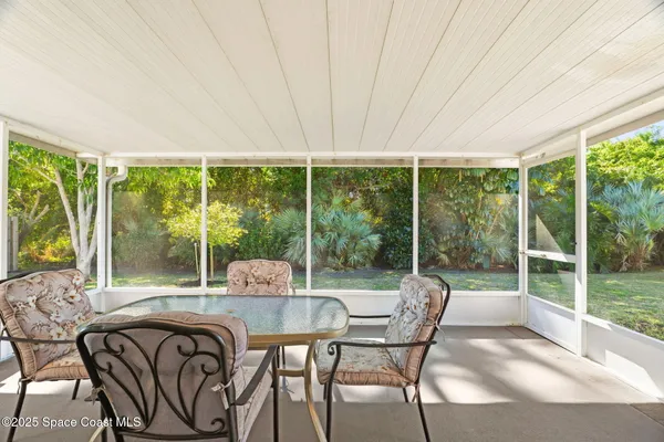 a dining room with furniture and large windows