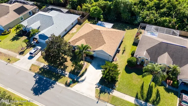 an aerial view of a house with a yard and swimming pool