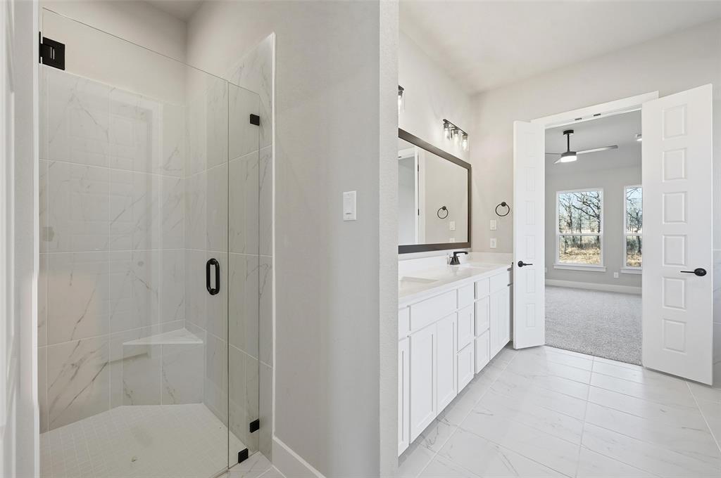 1053 Llano Way Poolville, TX 76487 - Photo 24 of 40 a bathroom with a bathtub shower and a sink