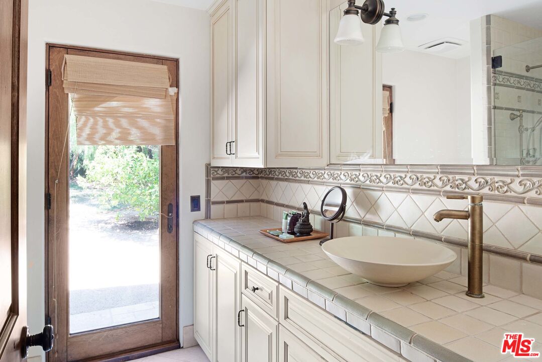 2251 Cold Canyon Road Calabasas, CA 91302 - Photo 21 of 47 a bathroom with a granite countertop sink and a mirror