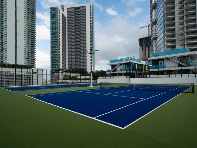 a dining room with furniture a chandelier and a large window