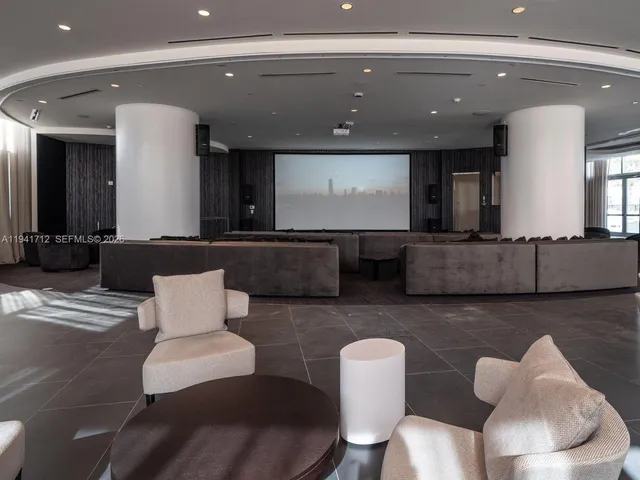 a living room with furniture a flat screen tv and a floor to ceiling window