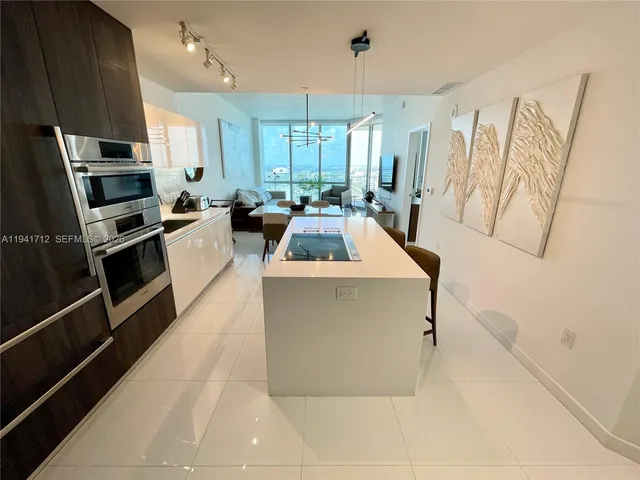 a bedroom with a large bed and a flat tv screen on dresser