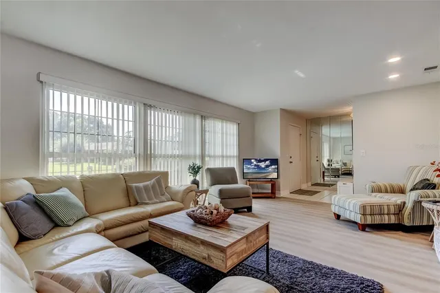 a living room with furniture ceiling fan and a wooden floor