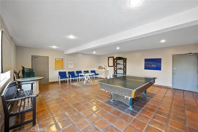 a living room with furniture a table and a pool table