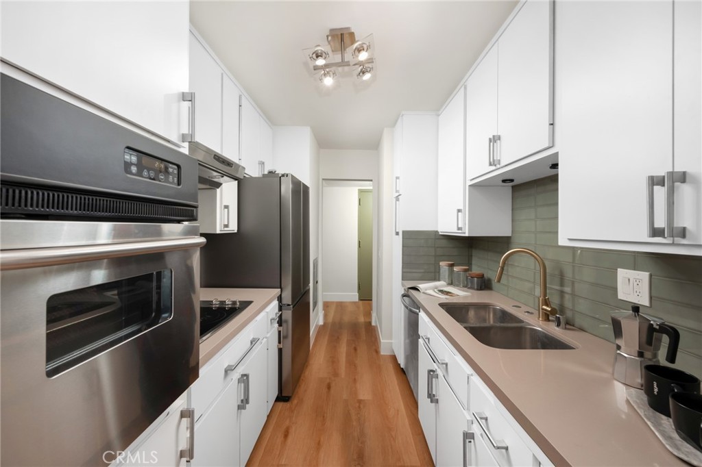 1010 Palm Avenue, Unit 207 West Hollywood, CA 90069 - Photo 7 of 21 a kitchen with granite countertop a sink stove and refrigerator