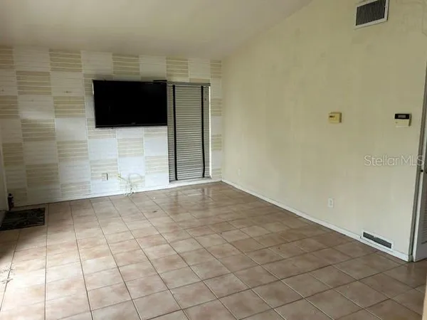 a view of a livingroom with an empty space and a kitchen space