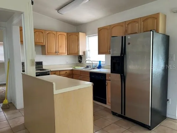 a kitchen with a refrigerator sink and cabinets