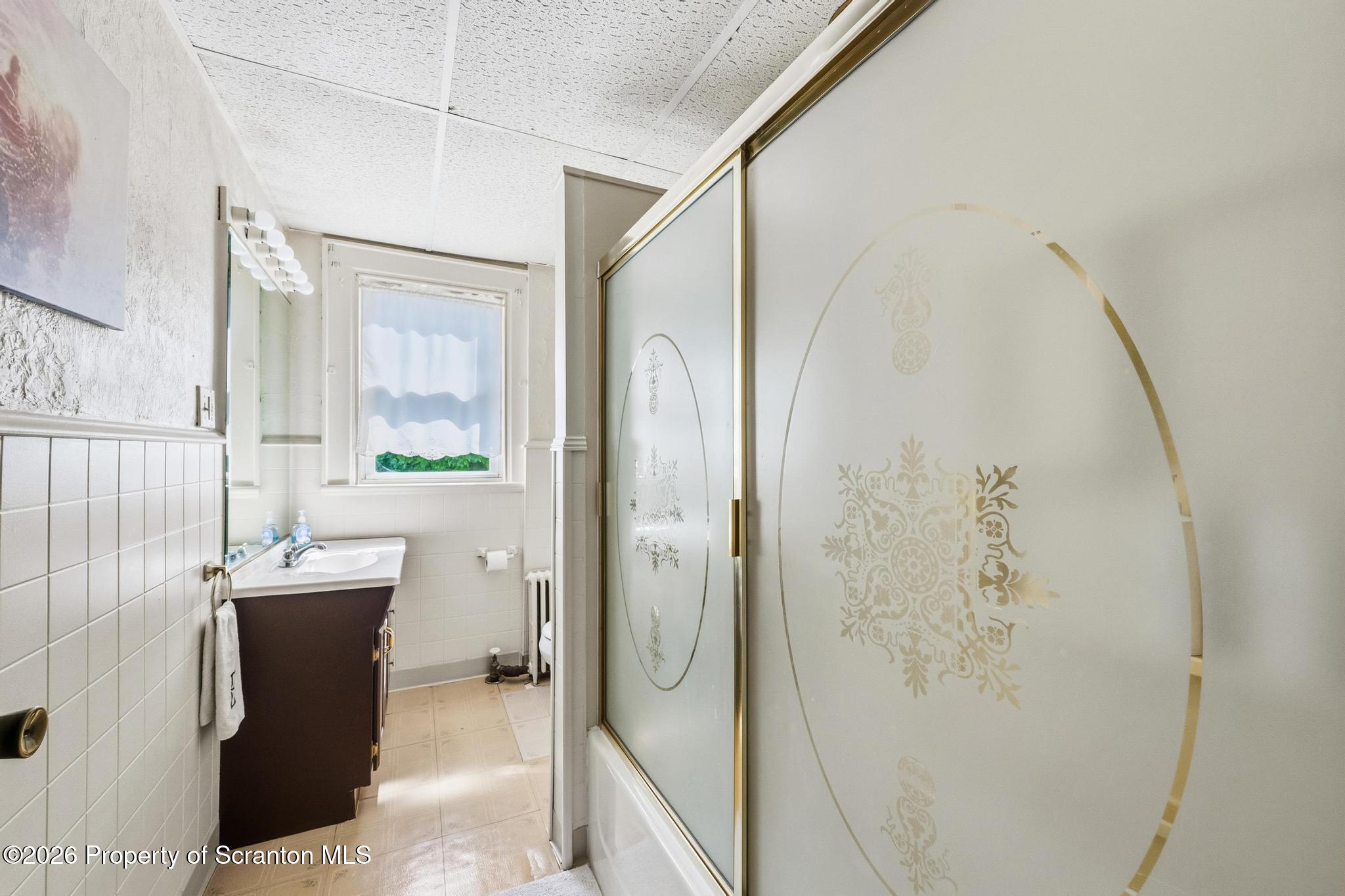 616 Myrtle Street Scranton, PA 18510 - Photo 21 of 65 a bathroom with a granite countertop sink a mirror and shower