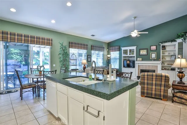 a dining hall with stainless steel appliances granite countertop a table and chairs