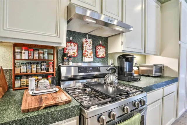a kitchen with stainless steel appliances granite countertop a stove and a sink