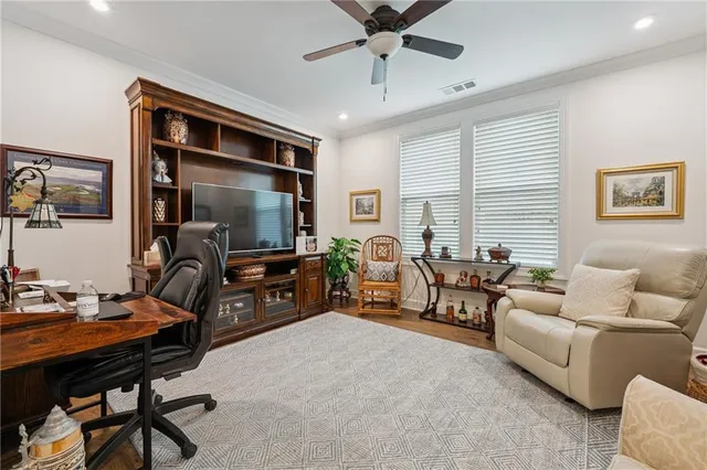 a living room with furniture and a flat screen tv with kitchen view