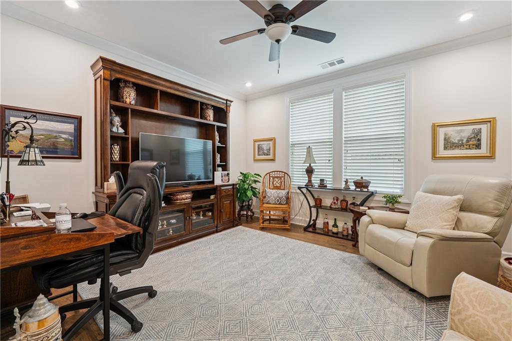 103 Rabun Court Hoschton, GA 30548 - Photo 12 of 22 a living room with furniture and a flat screen tv with kitchen view