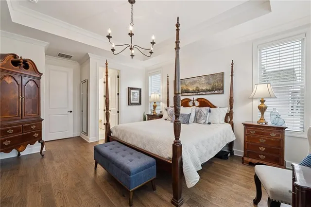 a bedroom with a bed chandelier and a window