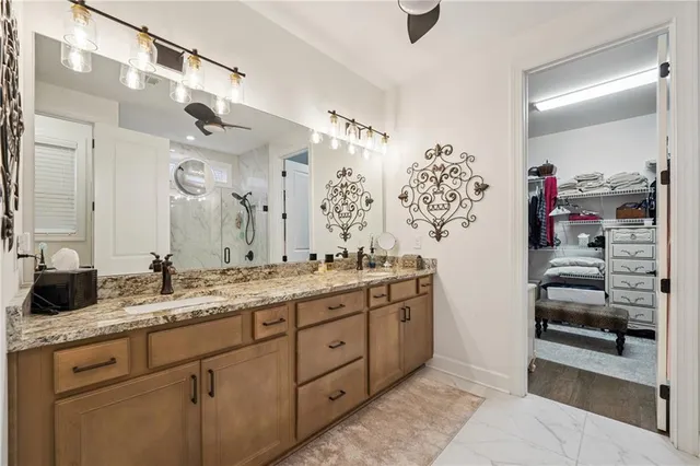 a spacious bathroom with a granite countertop sink a mirror and shower