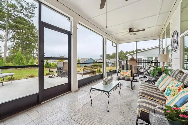 a living room with patio furniture and garden view