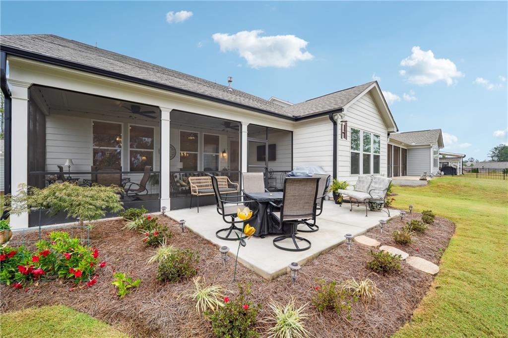 103 Rabun Court Hoschton, GA 30548 - Photo 21 of 22 a view of a backyard with sitting area and garden