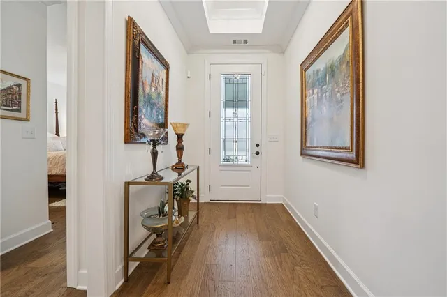 a view of a hallway with wooden floor and a bathroom