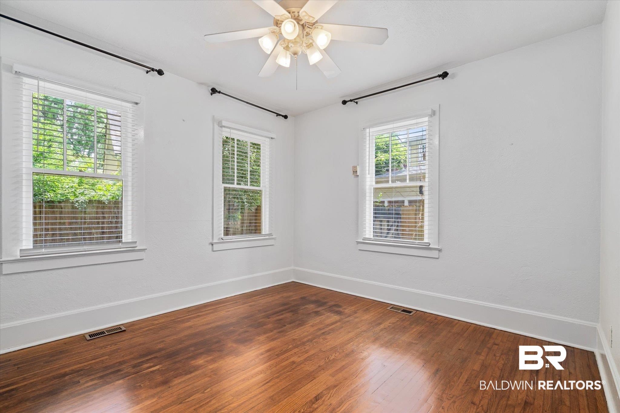 1159 Palmetto Street Mobile, AL 36604 - Photo 6 of 21 Spare room featuring a wealth of natural light, ceiling fan, and hardwood / wood-style floors