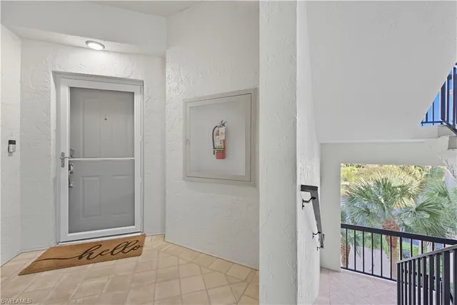 a view of a hallway with wooden floor and a bathroom