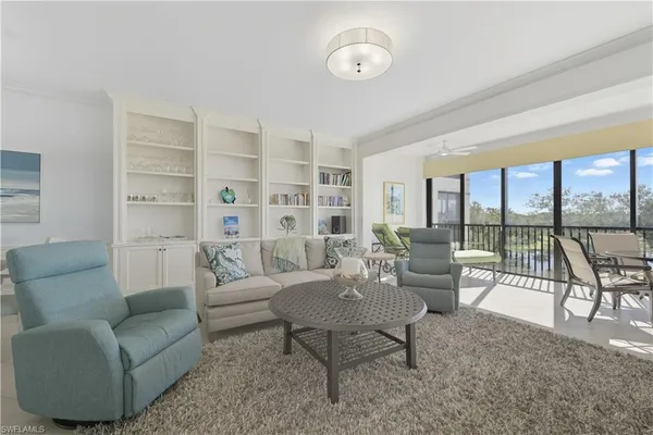 a living room with furniture and a floor to ceiling window